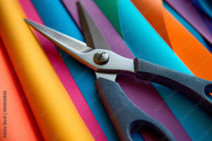 Scissors on colorful paper sheets